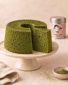MAS CHA Matcha chiffon cake on a cake stand next to a tin of MAS CHA Matcha